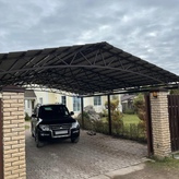 автонавес с двускатной крышей из металлочерепицы с арочным основанием